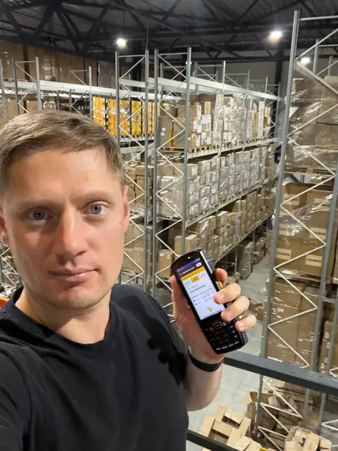 Сотрудник с терминалом сбора данных на складе UpSeller